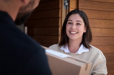 Kundin hält Paket in den Händen (Versand Schweiz)