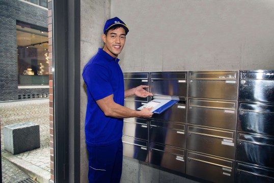 GLS driver sending a card inside a mailbox
