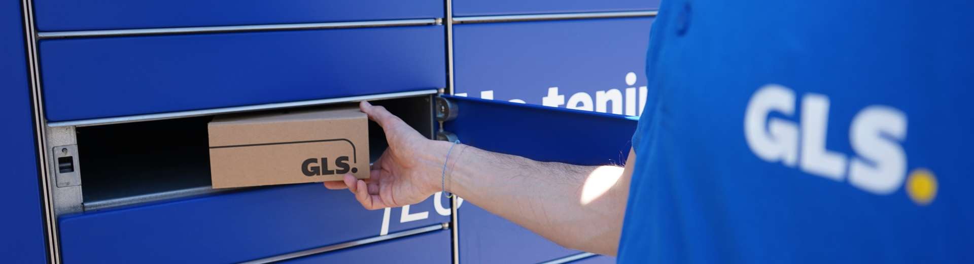 Parcel Locker inteligente de GLS para recoger paquetes en un centro comercial, con taquillas automáticas azules y pantalla táctil de autoservicio.