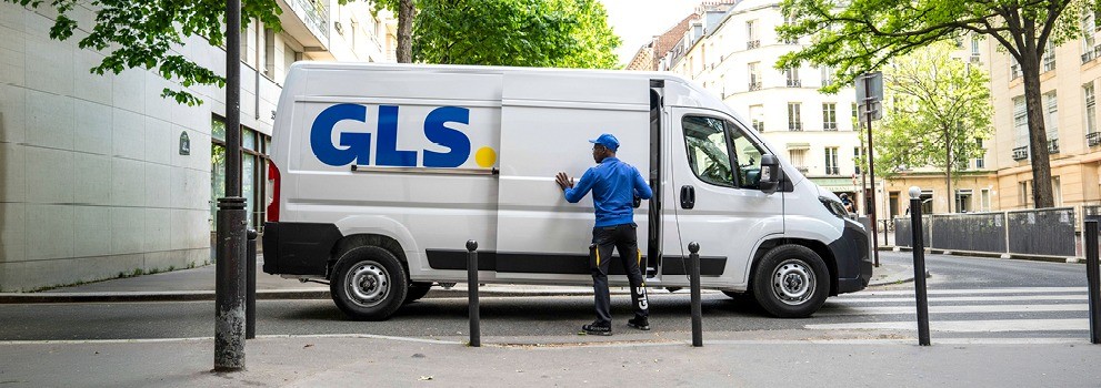 Camion de livraison GLS avec livreur ouvrant la porte latérale lors d’une tournée de distribution de colis en ville.