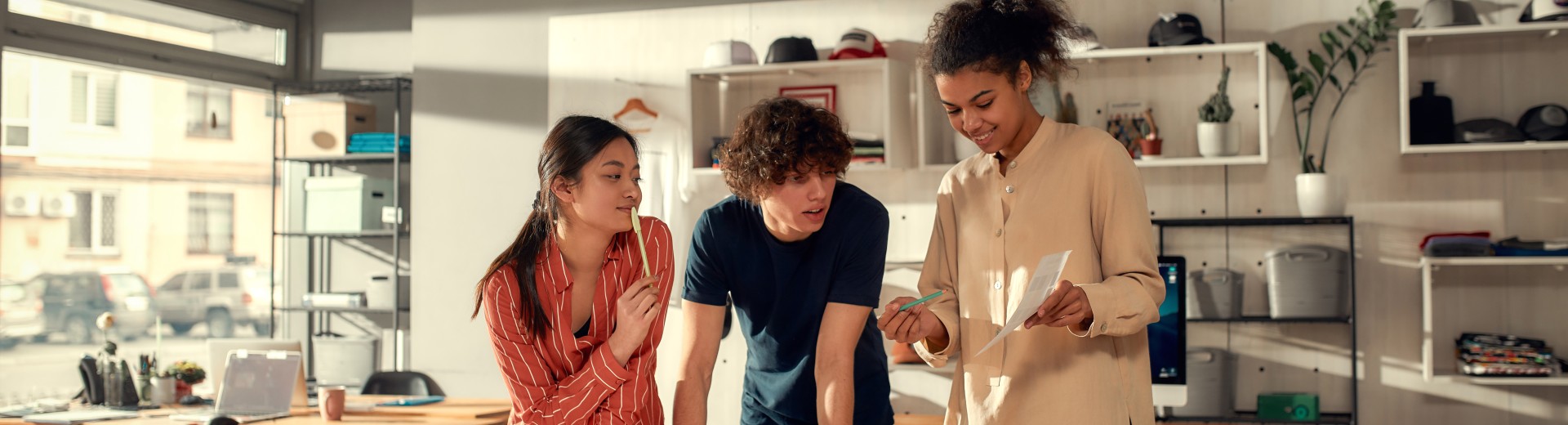 3 angajați tineri lucrând împreună la un proiect 