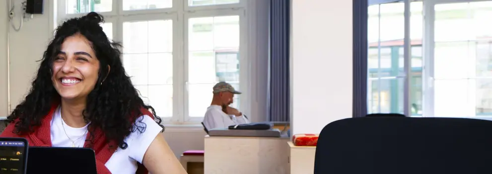 A woman smiling while using a computer.